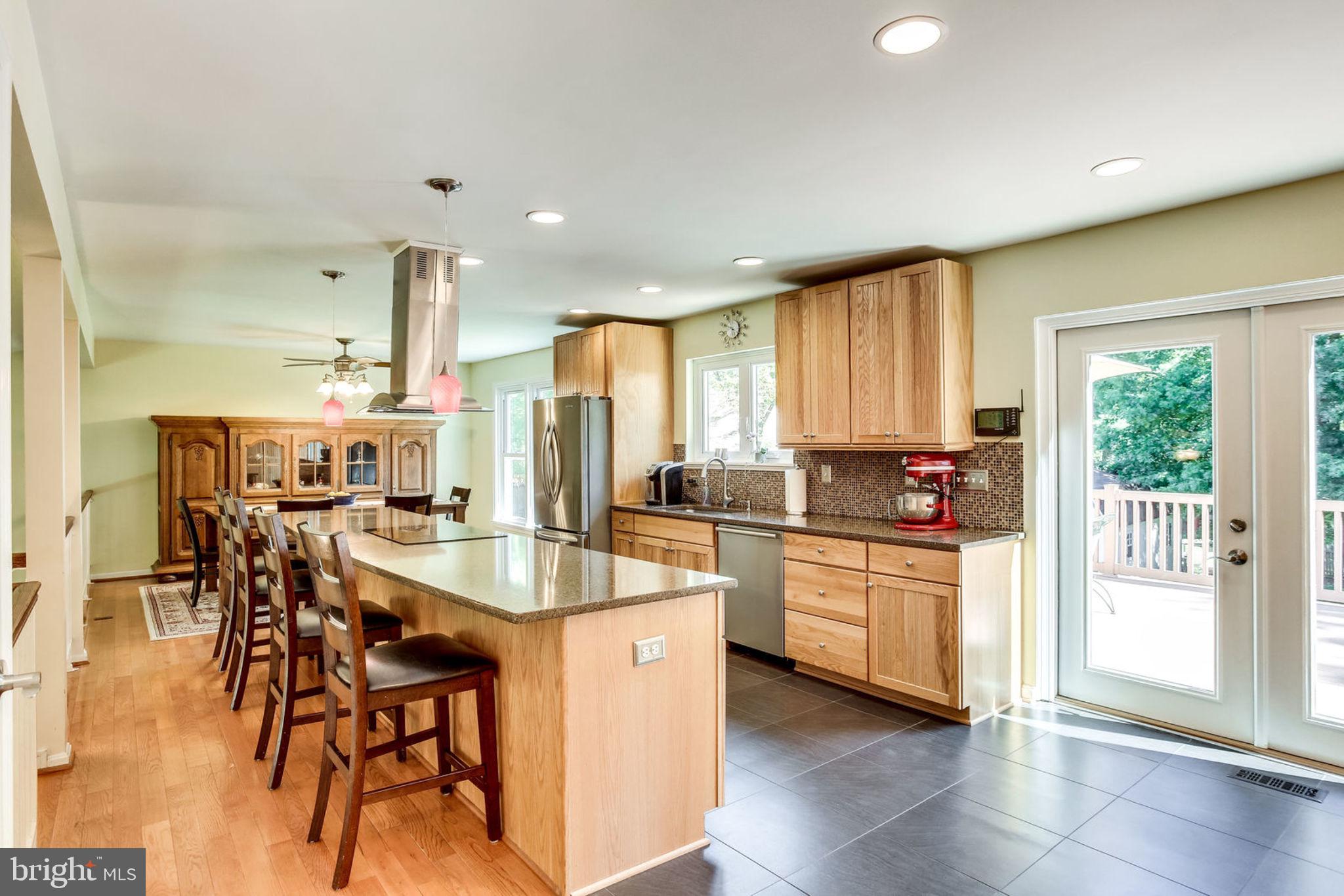 4305 Cub Run Road Chantilly, VA 20151 - Photo 14 of 46 a kitchen with stainless steel appliances kitchen island granite countertop a stove a sink a dining table and chairs