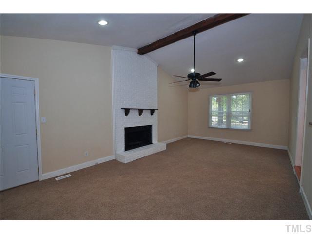 11420 Leesville Road Raleigh, NC 27613 - Photo 4 of 22 a view of an empty room with a fireplace and a window