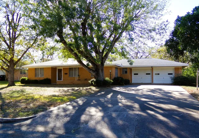 a front view of house with yard and tree