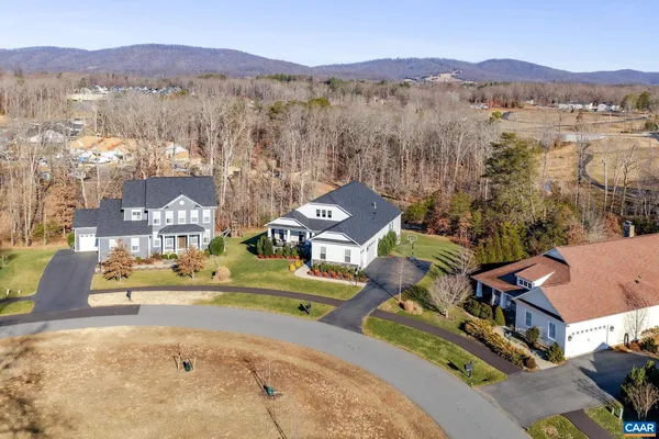 a view of a brick house with large windows and plants