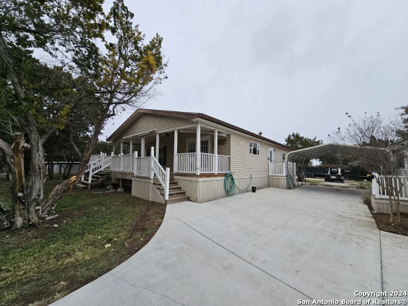 a white house that has tree in front of it
