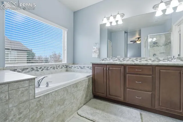 a spacious bathroom with a granite countertop sink and a bathtub