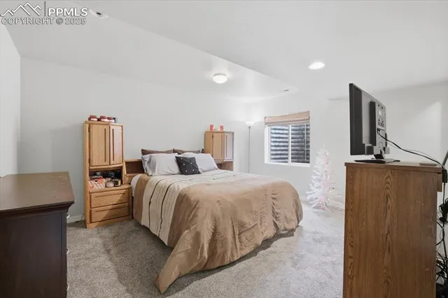 a spacious bedroom with a bed and wooden floor