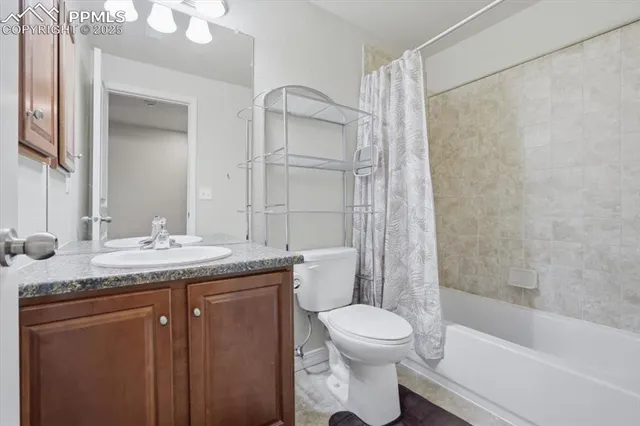 a bathroom with a granite countertop sink a toilet and shower