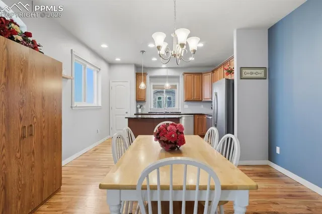 a view of a dining room with furniture a chandelier and wooden floor