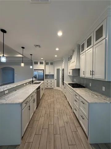 a large kitchen with stainless steel appliances granite countertop a stove a sink and a refrigerator