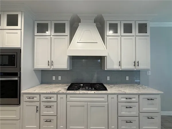 a kitchen with granite countertop a stove a sink and a microwave