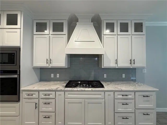 a kitchen with granite countertop a stove a sink and a microwave