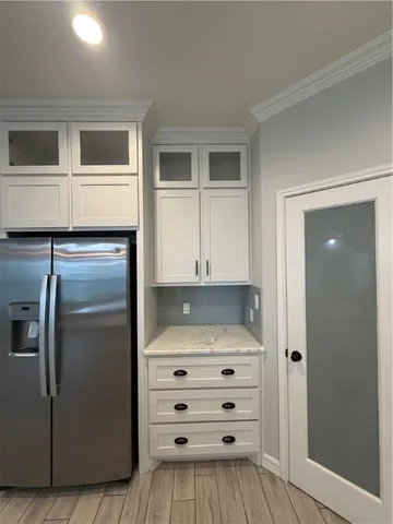 a kitchen with white cabinets and refrigerator