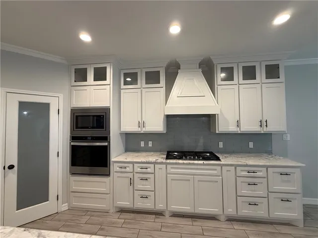 a kitchen with granite countertop a stove cabinets and refrigerator