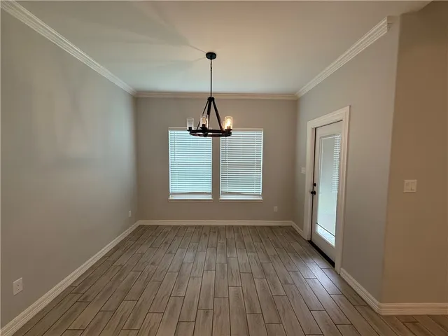 a view of empty room with wooden floor fan and window