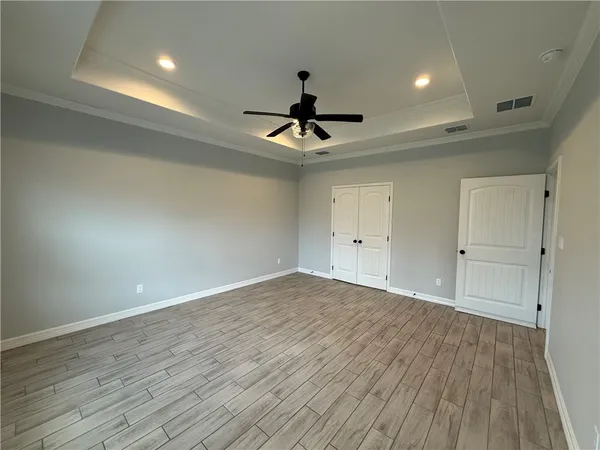 a view of empty room with wooden floor