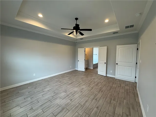 a view of a hallway with wooden floor and closet area