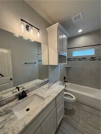a bathroom with a sink mirror toilet and bathtub