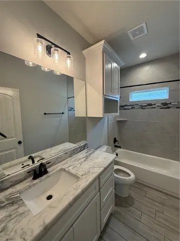 a bathroom with a sink mirror toilet and bathtub