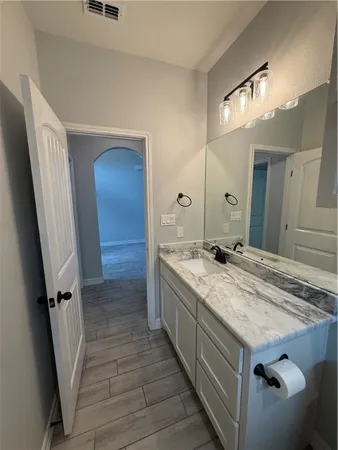 a bathroom with a granite countertop sink a mirror and a shower