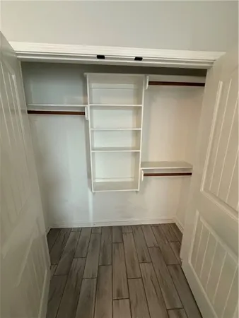 a view of a walk in closet with wooden floor