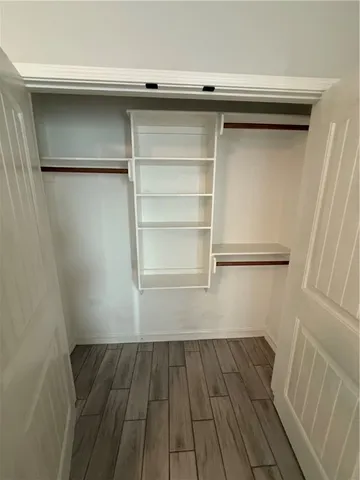a view of a walk in closet with wooden floor