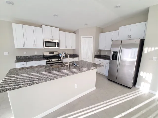 a kitchen with stainless steel appliances a refrigerator sink stove microwave and cabinets