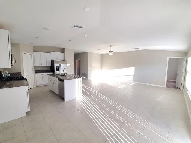 a kitchen with stainless steel appliances kitchen island granite countertop a stove a sink and a refrigerator