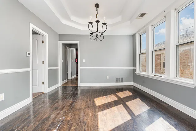 a view of empty room with wooden floor and windows