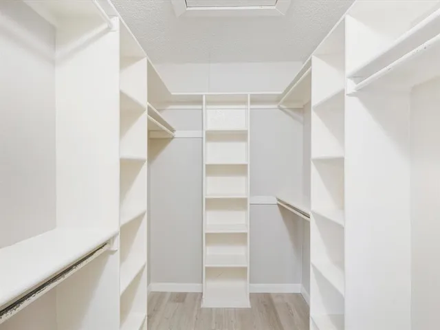 a view of walk in closet with empty racks