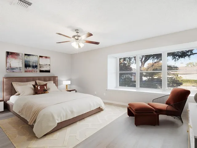 a bedroom with a bed and a large window