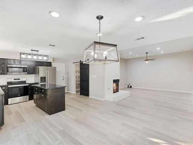 a view of a kitchen with a stove cabinets and a floor to ceiling window