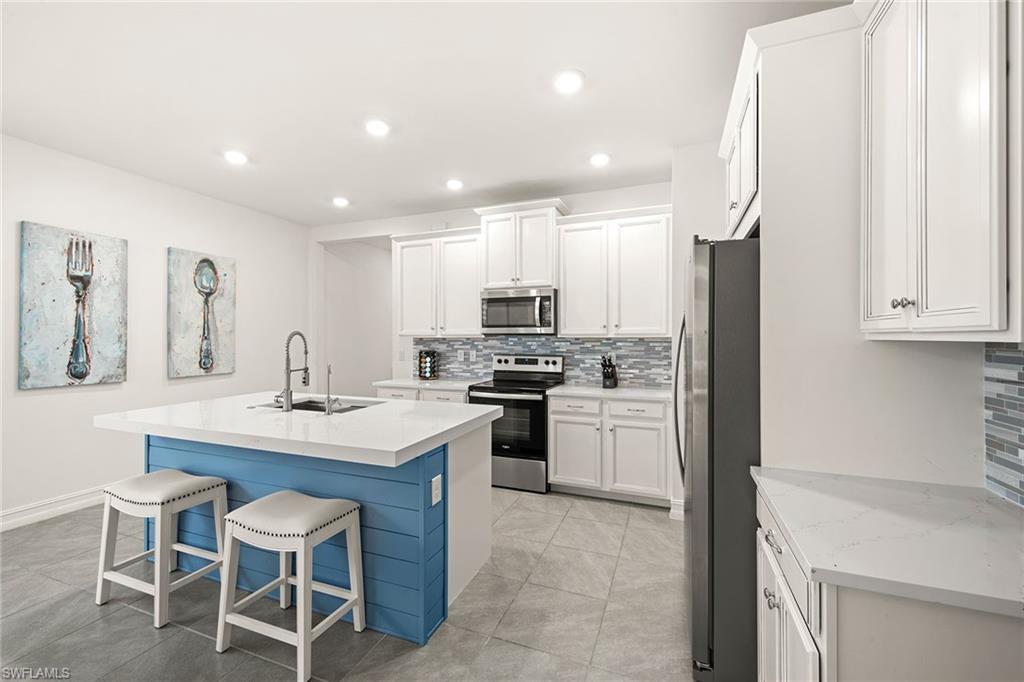 28419 Captiva Shell Loop Bonita Springs, FL 34135 - Photo 10 of 41 a kitchen with a sink stainless steel appliances and white cabinets