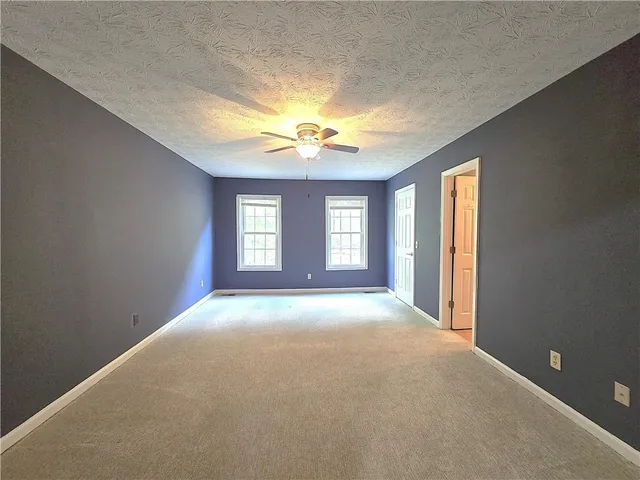 a view of a big room with windows and chandelier fan