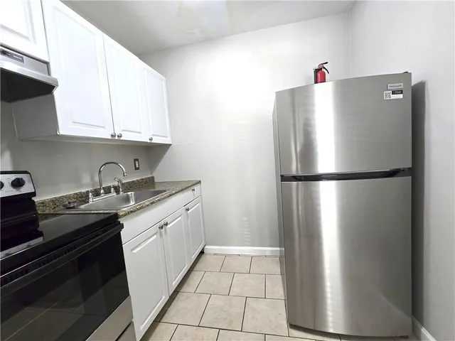 a kitchen with stainless steel appliances granite countertop a refrigerator and a sink