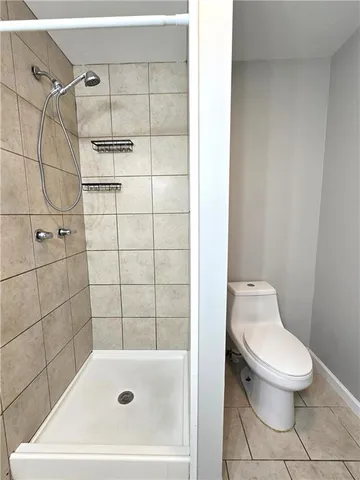 a white toilet sitting next to a bath tub and a shower