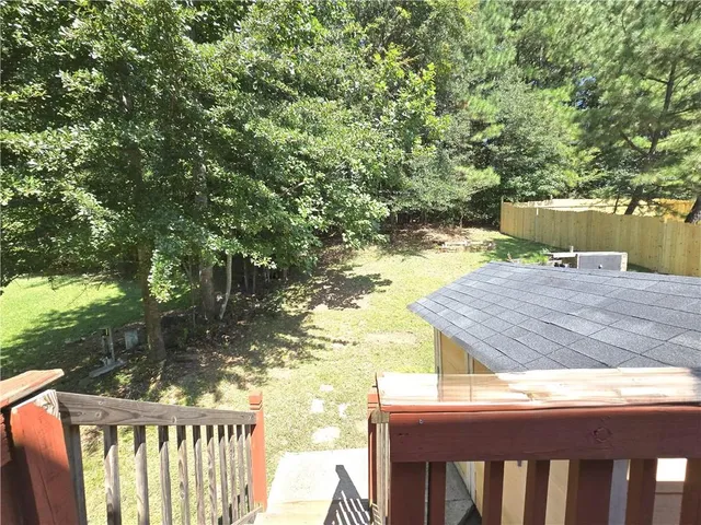 a view of a wooden deck and a backyard