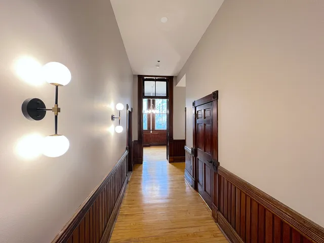 a view of a hallway with wooden floor