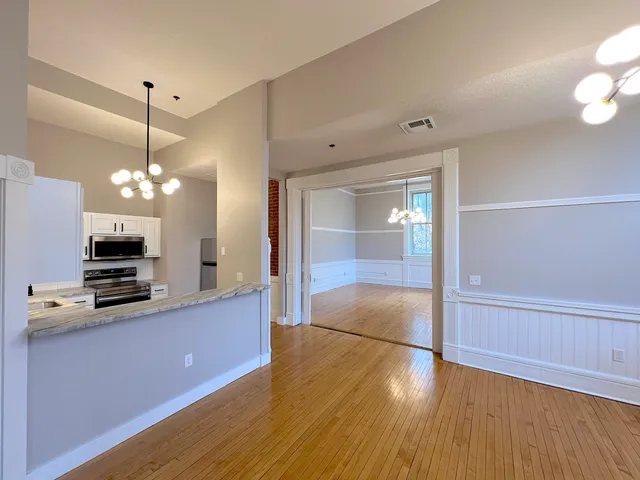 a view of a kitchen with wooden floor and cabinets