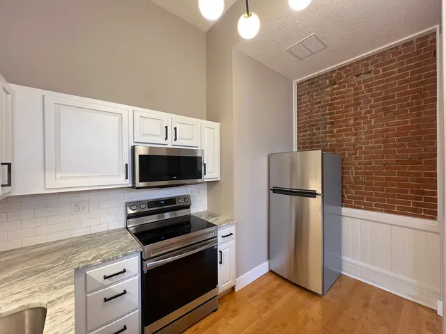 a kitchen with a refrigerator stove and microwave