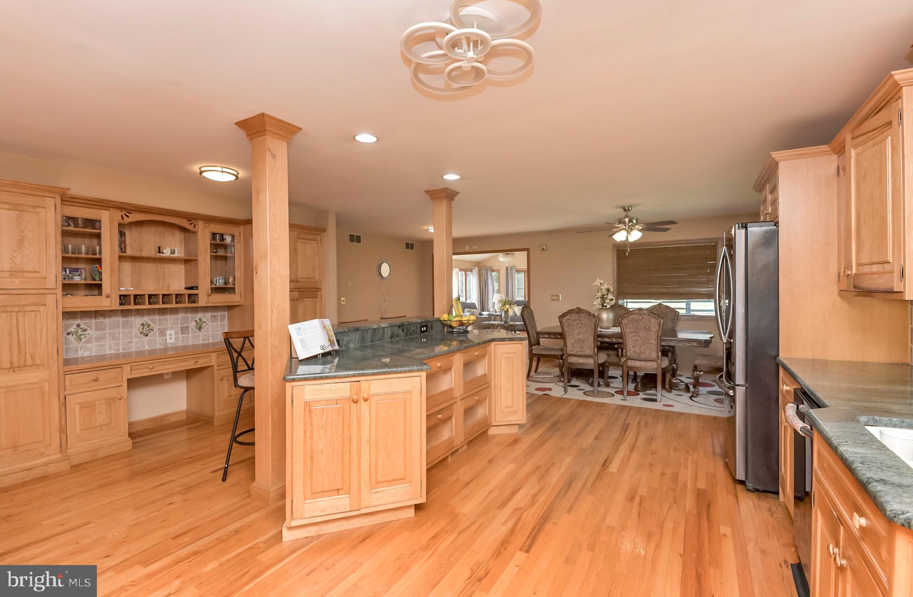 467 Gordon Road Robbinsville, NJ 08691 - Photo 11 of 41 a kitchen with stainless steel appliances granite countertop a stove top oven a refrigerator a dining table and chairs with wooden floor
