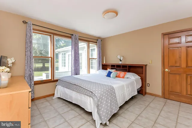 a bedroom with a bed and a large window