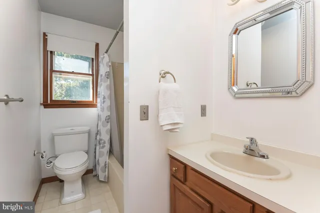 a bathroom with a toilet a sink and mirror