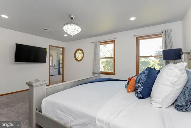 a bedroom with a bed and a tv on dresser