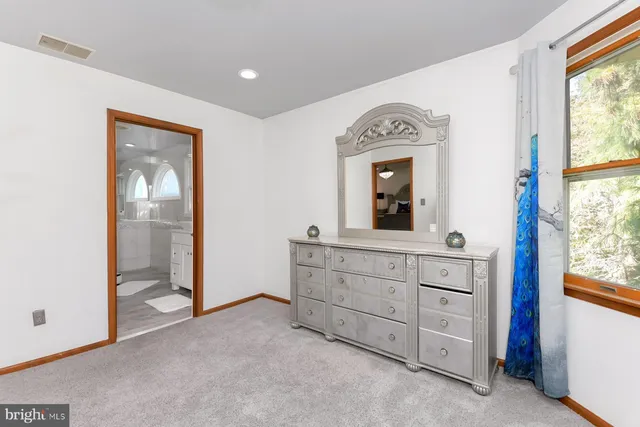 a room with a bed mirror and a window