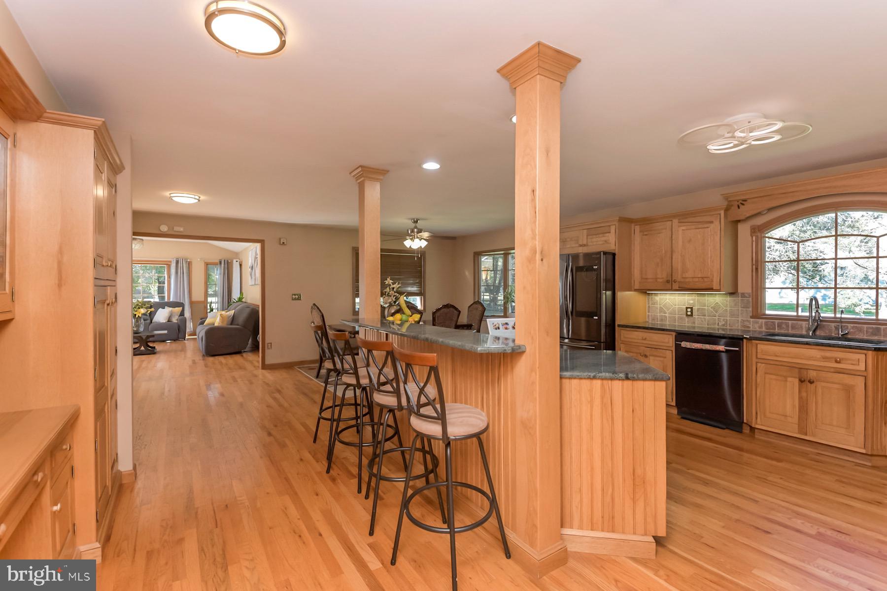 467 Gordon Road Robbinsville, NJ 08691 - Photo 9 of 41 a kitchen with stainless steel appliances granite countertop a stove top oven a sink dishwasher a dining table and chairs with wooden floor