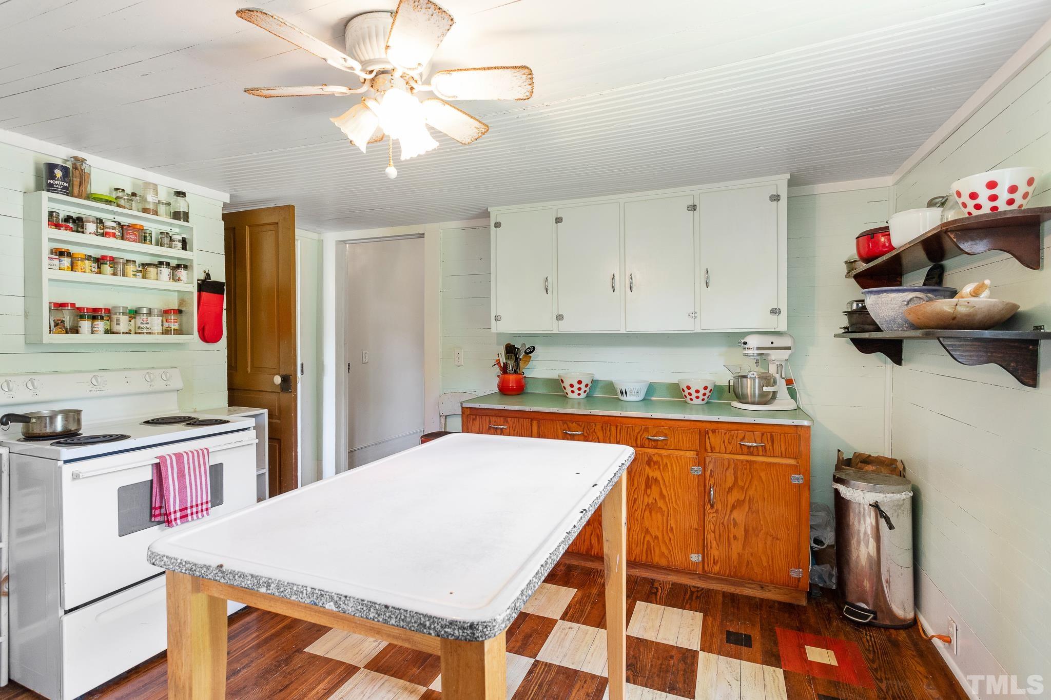 599 Federal Road Benson, NC 27504 - Photo 18 of 30 a large kitchen with a stove a refrigerator a sink dishwasher with a dining table and chairs with wooden floor