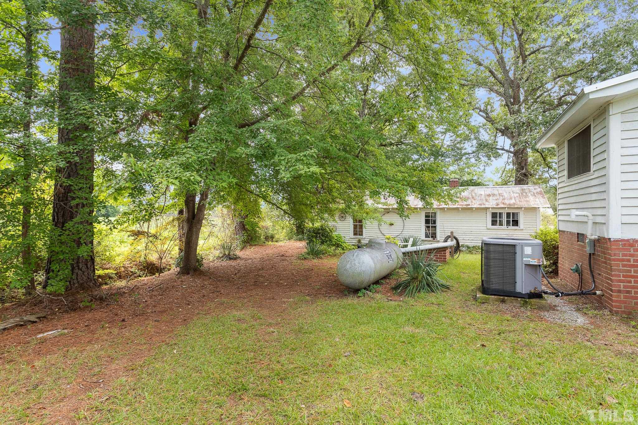 599 Federal Road Benson, NC 27504 - Photo 6 of 30 a view of a backyard with table and chairs and a barbeque