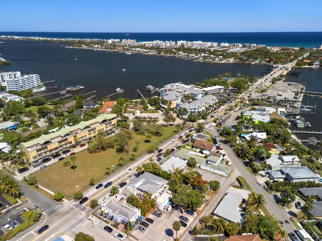 an aerial view of ocean and residential houses with outdoor space