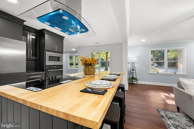 a kitchen with kitchen island granite countertop a sink counter top space and stainless steel appliances
