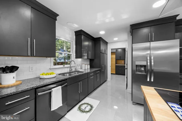 a kitchen with stainless steel appliances kitchen island granite countertop a refrigerator and a stove top oven
