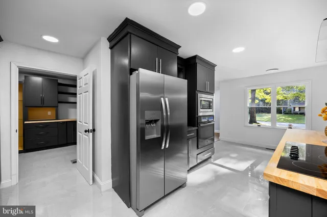 a view of an empty room with wooden floor and a ceiling fan