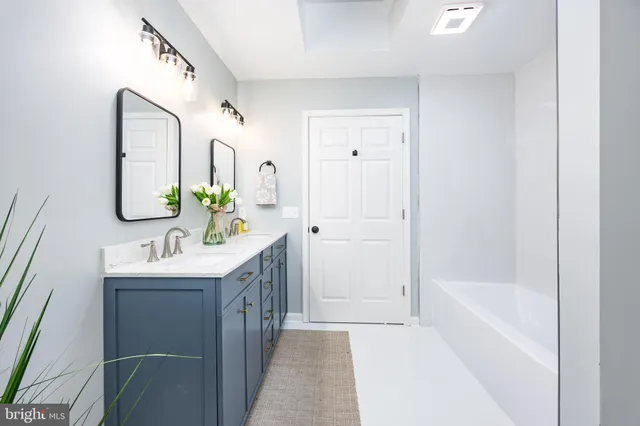 a bathroom with a granite countertop sink a mirror and a shower