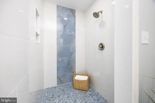 an empty room with wooden floor ceiling fan and windows